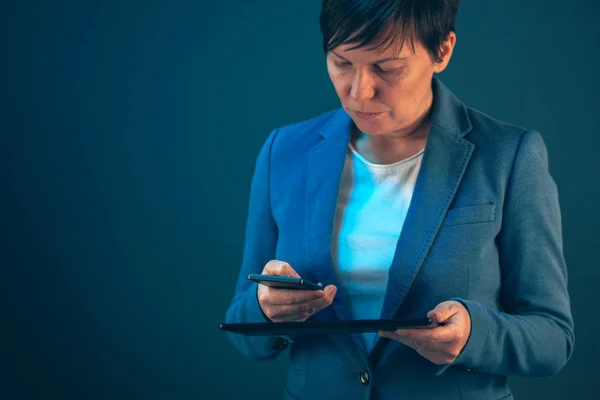 Affärskvinna med hjälp av mobiltelefon och tablet PC — Stockfoto