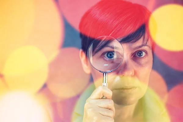 Beautiful caucasian woman looking through a magnifying glass — Stock Photo, Image