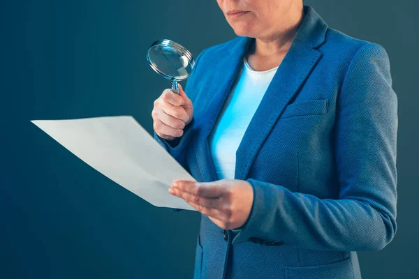Inspetor fiscal feminino que olha para o documento com lupa — Fotografia de Stock