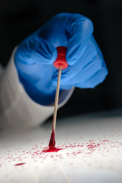 Forensic technician taking DNA sample from blood stain — Stock Photo, Image