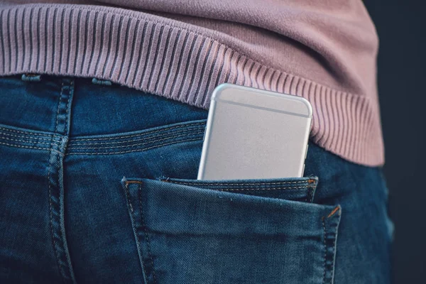 Mulher com smartphone em azul jeans bolso traseiro — Fotografia de Stock