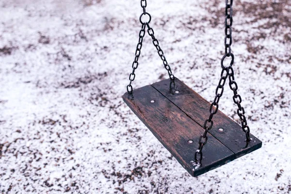 Balanço vazio no parque infantil sob a neve — Fotografia de Stock