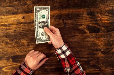 Bir dolarlık banknot sunan kadın
