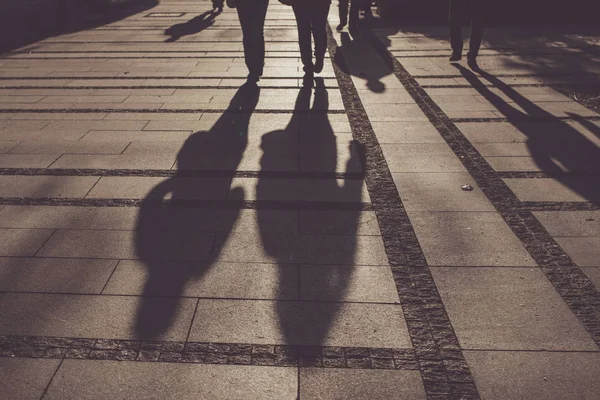 Silhouettes of people walking on city street Stock Picture