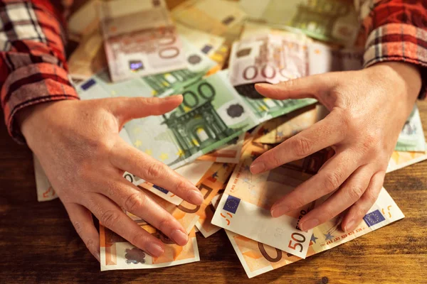 Greedy hands withdrawing pile of euro banknotes cash — Stock Photo, Image
