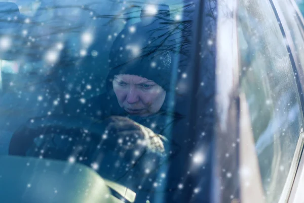 Женщина не может завести машину в холодный снежный зимний день — стоковое фото