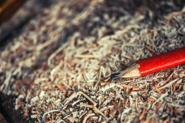 Red pencil on carpenters workshop table — Stock Photo, Image