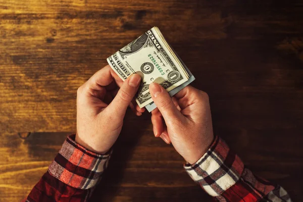 Женщина платит банкнотами по доллару США — стоковое фото