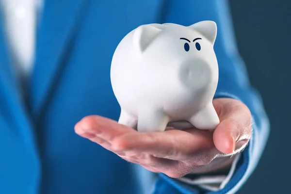 Wütendes Sparschwein in der Hand der Geschäftsfrau — Stockfoto