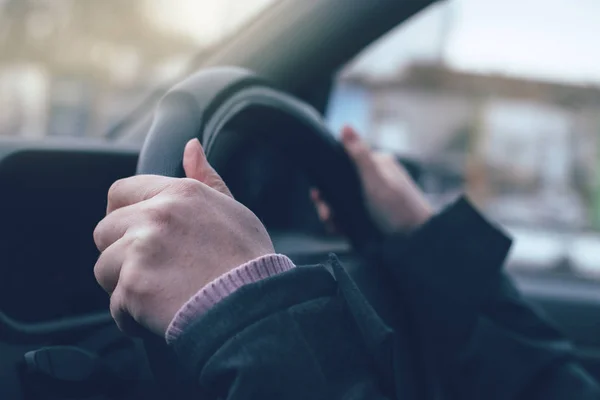 Tangan wanita mencengkeram roda kemudi mobil — Stok Foto