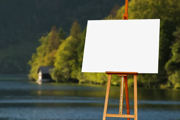 Blank painter artist canvas on easel with lake in background — Stock Photo, Image