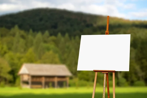 Pintor en blanco lienzo artista sobre caballete con montaña en el fondo —  Fotos de Stock