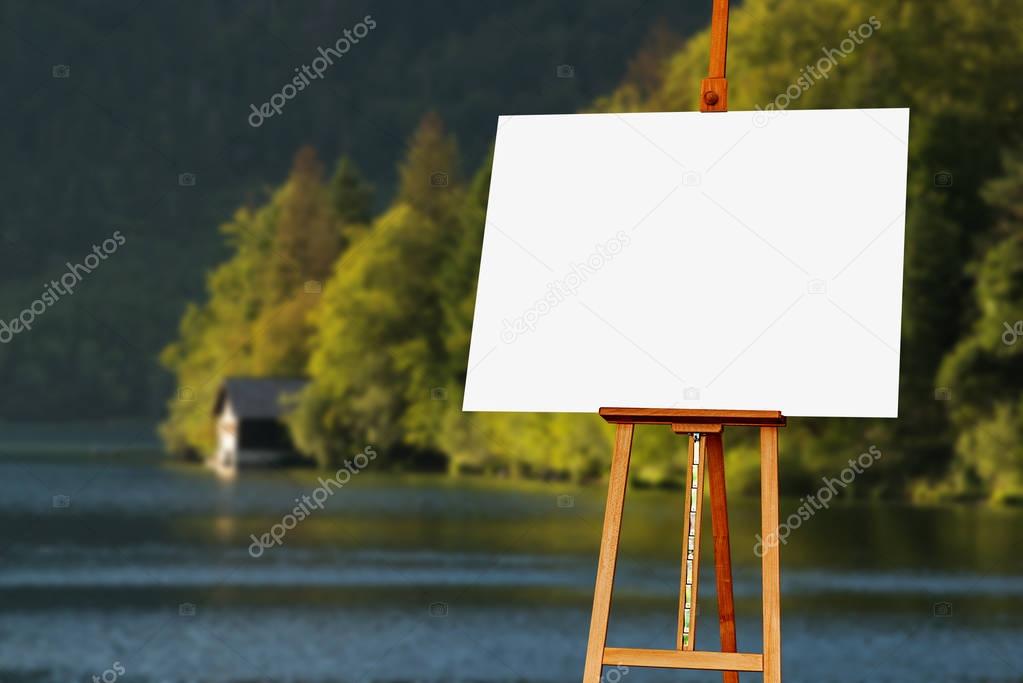 Blank painter artist canvas on easel with lake in background