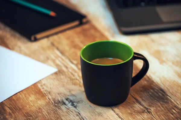Черная чашка кофе на рабочем столе — стоковое фото