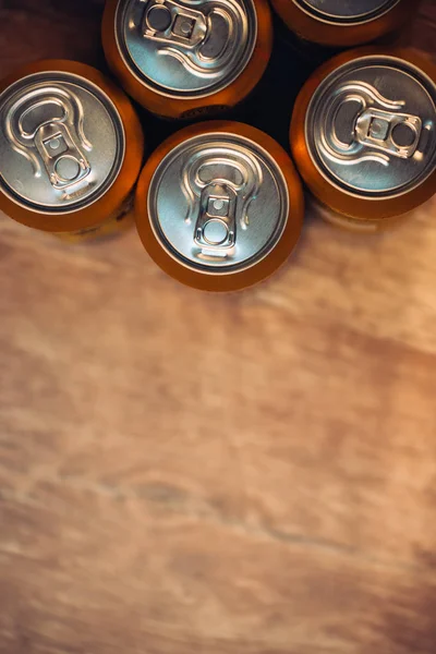 Beer cans on rustic wooden table top view — Stock Photo, Image