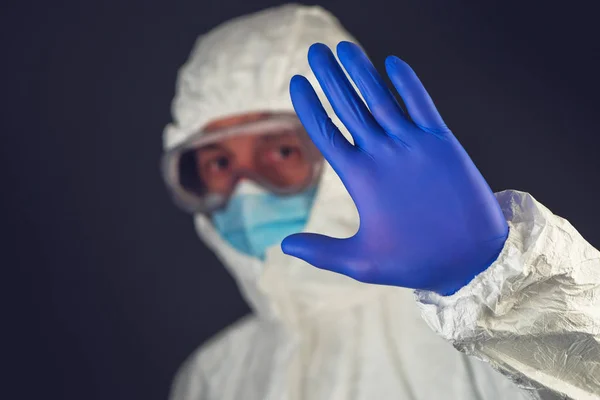 Медичний вчений в захисному одязі жестикулює знак зупинки в — стокове фото