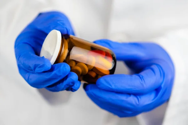 다양 한 약과 메디의 레이블이 없는 병을 들고 여성 의사 — 스톡 사진