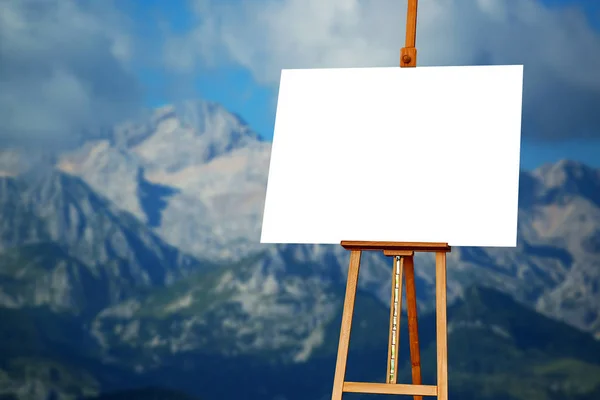 Pittore bianco tela artista su cavalletto con montagna sullo sfondo — Foto Stock
