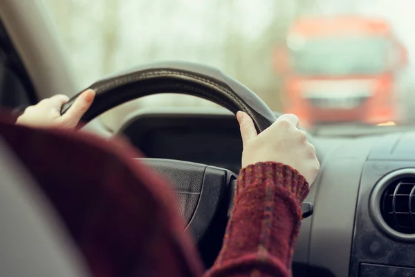 在道路上驾驶汽车走向一辆大卡车的女人 — 图库照片