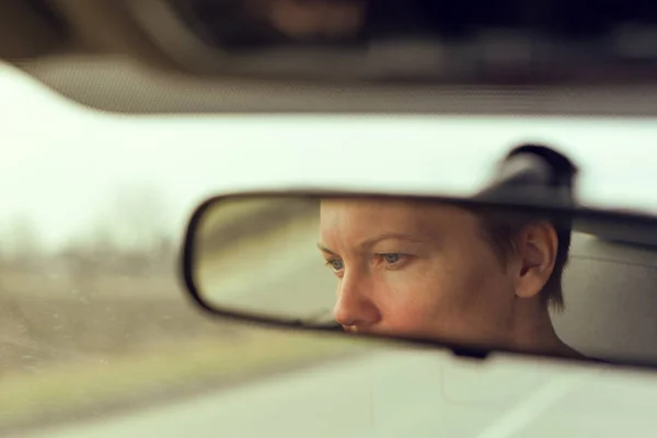 Riflessione del volto femminile nello specchio retrovisore dell'auto — Foto Stock