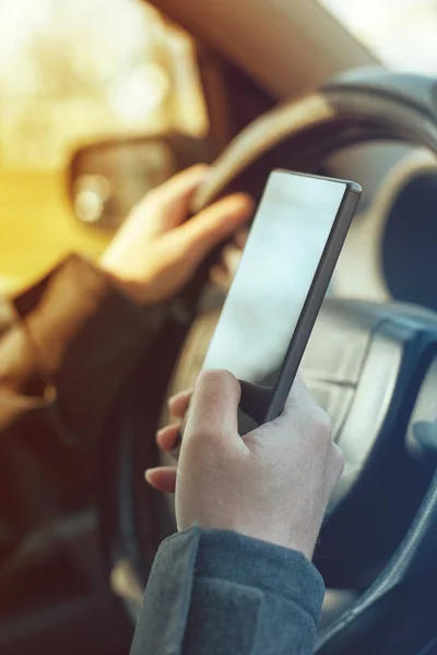 Driving car and using mobile phone to send text message — Stock Photo, Image