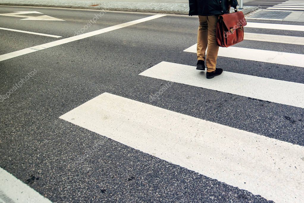 Businessman on pedestrian zebra crossing on his way to work