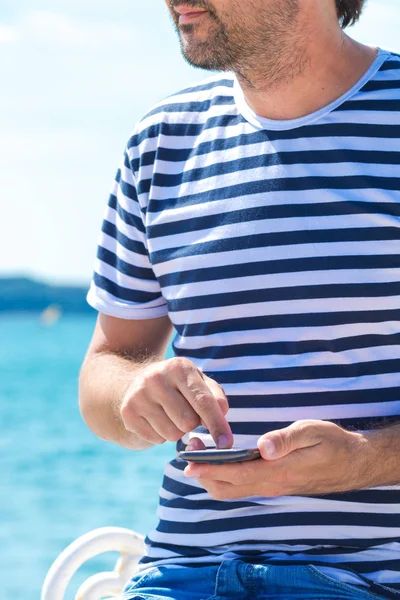 Mannelijke toeristische met behulp van mobiele telefoon aan zee op zomervakantie — Stockfoto