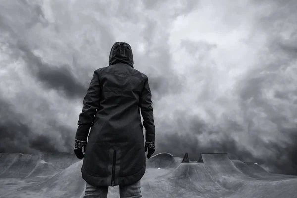 Unrecognizable hooded person in empty skateboarding park — Stock Photo, Image