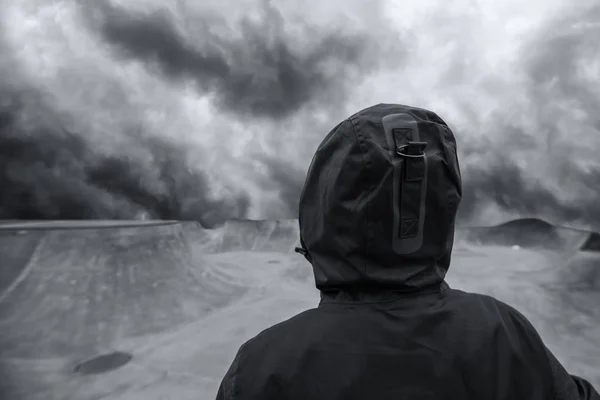 Unrecognizable hooded person in empty skateboarding park — Stock Photo, Image