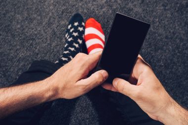 Cep telefonu kullaranarak ABD bayrağı çorap giyen adam