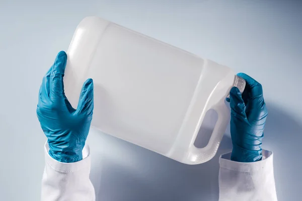 Chemické vědec otevření bílé nepopsané plastovým zásobníkem kanystr — Stock fotografie