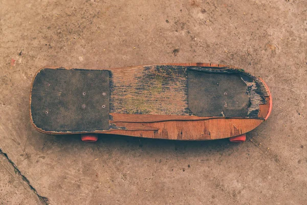 Old weathered skateboard on concrete surface — Stock Photo, Image
