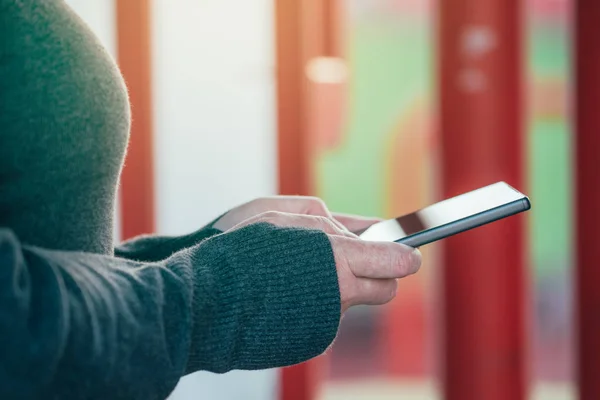 Primer plano de las manos femeninas usando el teléfono móvil en la calle — Foto de Stock