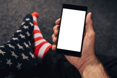 Cep telefonu kullaranarak ABD bayrağı çorap giyen adam