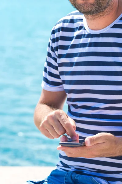 Cep telefonuyla deniz kenarında yaz tatilde erkek turist — Stok fotoğraf