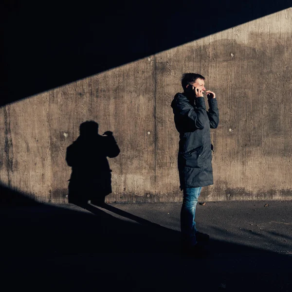 Ernsthafte authentische Frau, die auf der Straße mit dem Handy telefoniert — Stockfoto