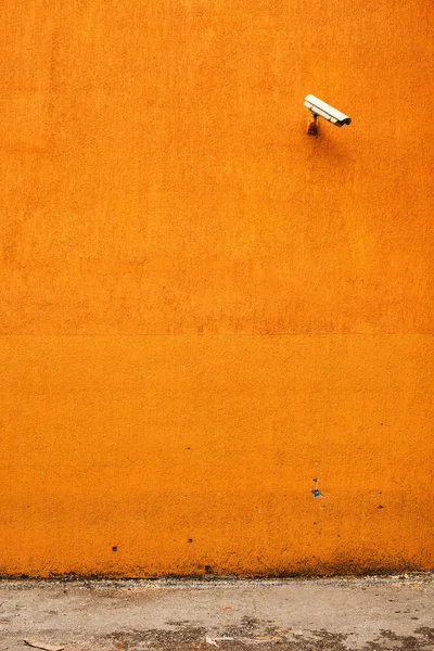 橙色的建筑外墙上的闭路电视摄像机 — 图库照片