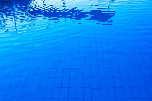 Superfície exterior azul da água da piscina como fundo abstrato — Fotografia de Stock