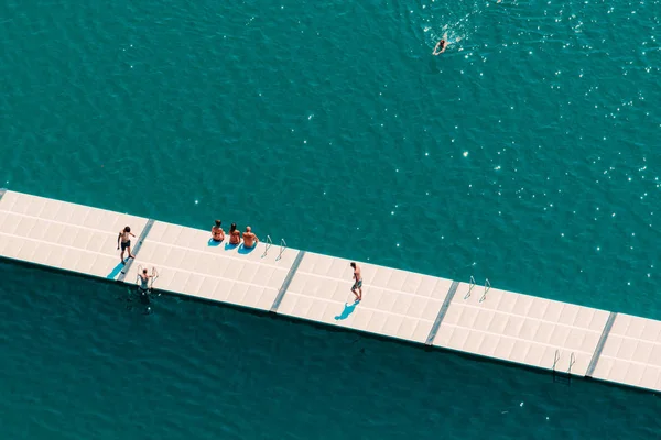 Des gens méconnaissables profitant de l'après-midi d'été sur le lac — Photo