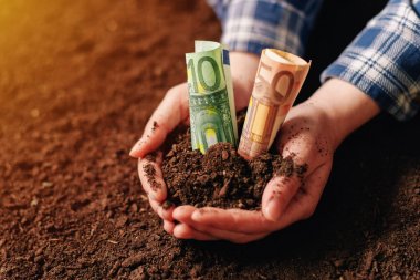 Hands with fertile soil and euro money banknotes clipart