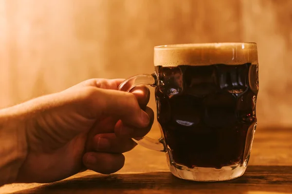 Mannen dricker mörk öl i brittiska dimpled glas pint mugg — Stockfoto