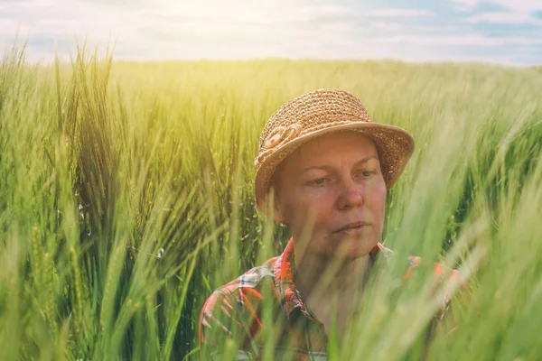 Kadın çiftçi alan kulaklarında buğday incelenmesi