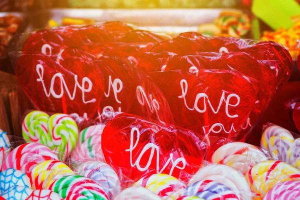 Piruleta en forma de corazón con palabra amor en el mercado callejero —  Fotos de Stock