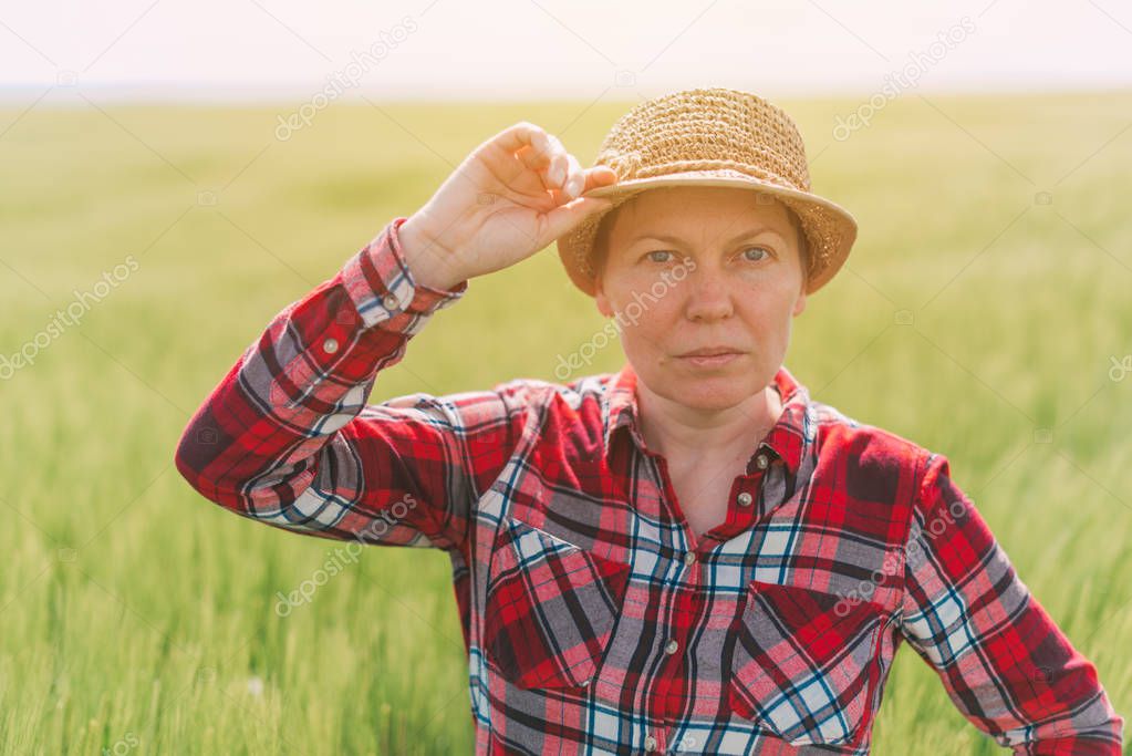 Female farmer posing in cultivated wheat field