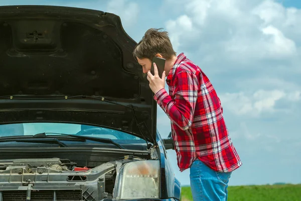 Woman with broken car on country road talking on mobile — Stock Photo, Image