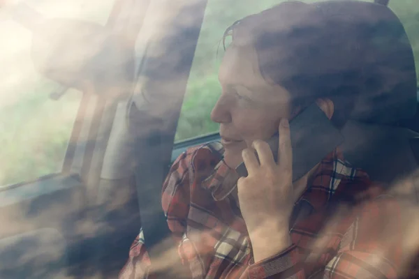 Mujer sonriente hablando por teléfono móvil en coche — Foto de Stock