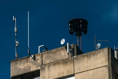 Civil defense siren on top of apartment building clipart