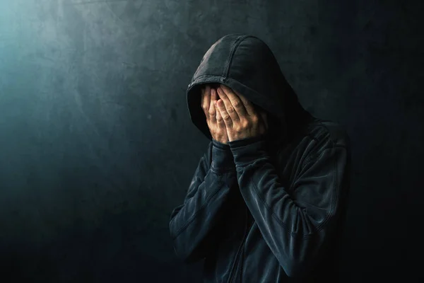 Uomo disperato in giacca con cappuccio sta piangendo — Foto Stock