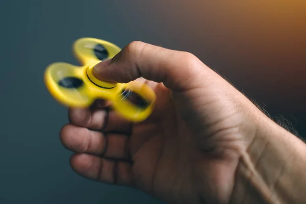Spinner fidget amarillo en mano masculina — Foto de Stock