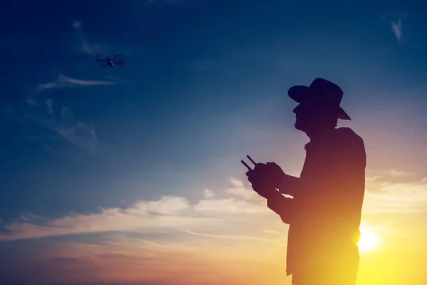 Silhouette de l'agriculteur à l'aide d'une télécommande par drone — Photo